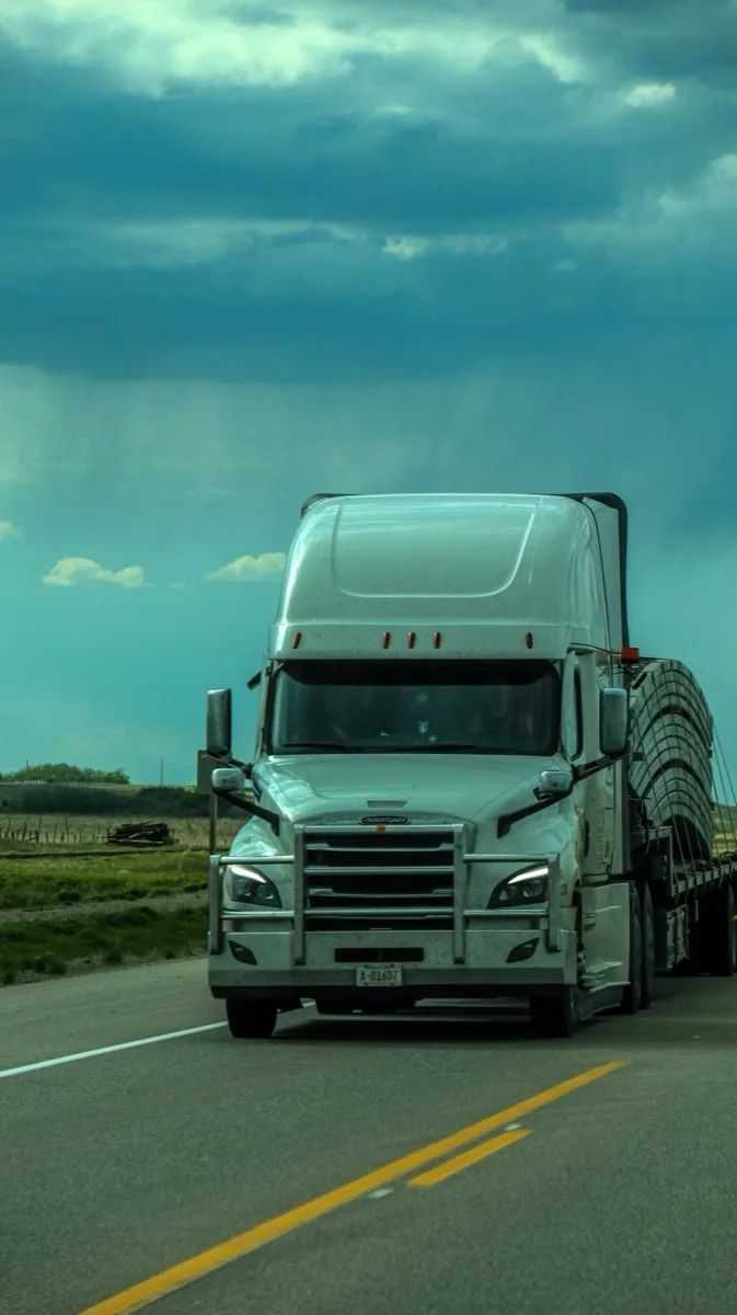 Semi truck on a highway under a dramatic sky